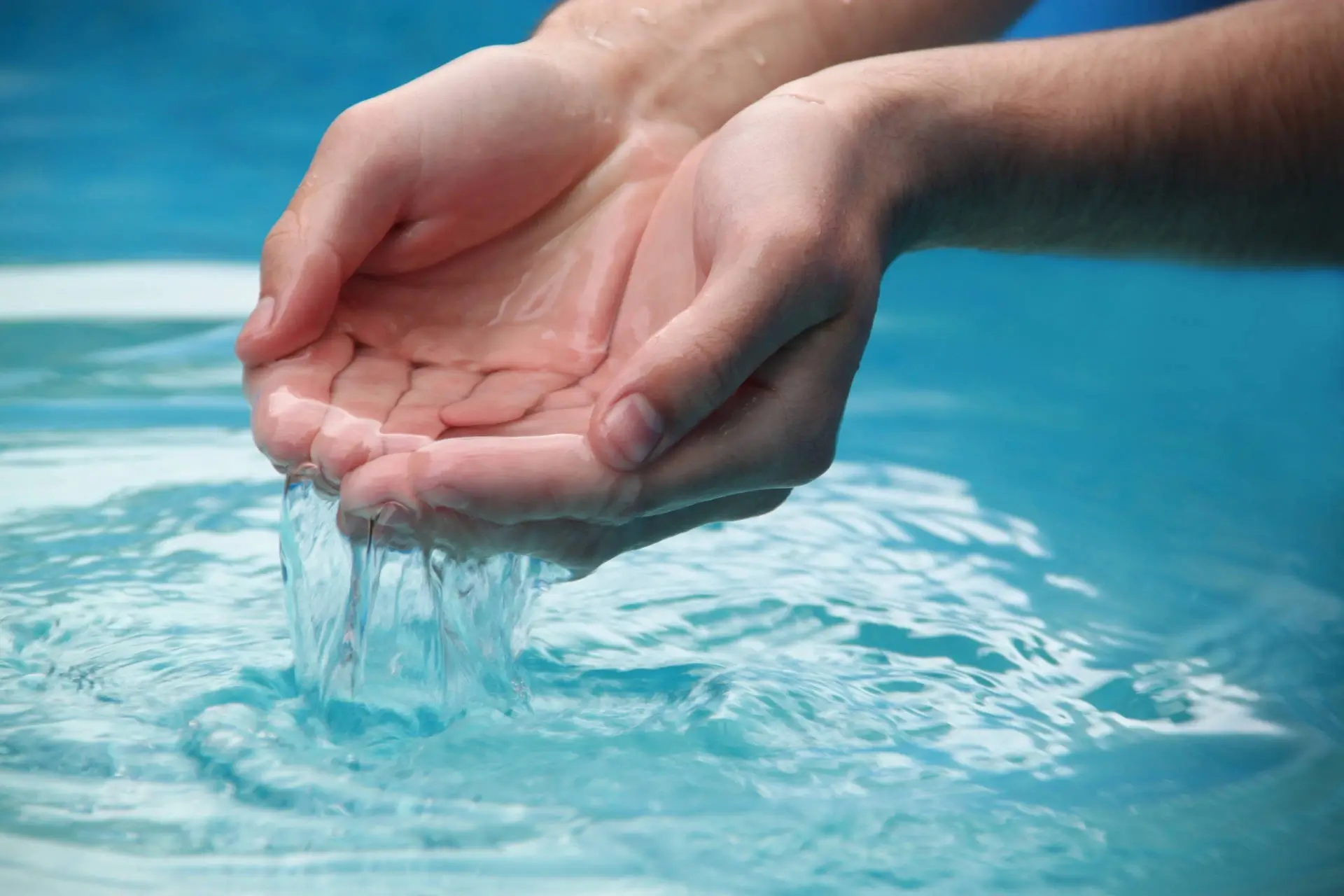 A hand holding crystal clear water